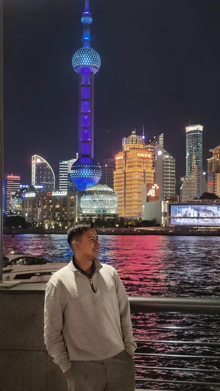Andrei en el Bund de Shanghái, con la Torre Perla Oriental iluminada